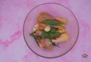 La foto raffigurante le cosce di pollo messe con aromi e aglio, per la preparazione delle cosce di pollo alla birra
