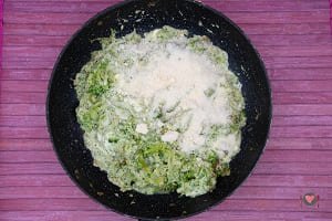 Il formaggio grattugiato aggiunto nel sugo per la preparazione della pasta broccoli e acciughe