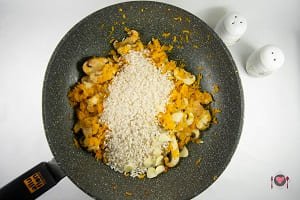 La tostatura del riso per la preparazione del risotto zucca e funghi