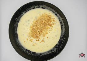 La foto raffigurante l'aggiunta di formaggio grattugiato e noci per la preparazione degli Gnocchetti gorgonzola e noci