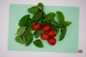 La foto raffigurante i pomodorini e il basilico per la preparazione della pasta fredda con pesto e gamberetti