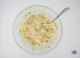 La foto raffigurante gli ingredienti mescolati per la preparazione della Torta salata con carciofi e patate