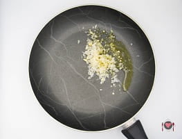 La foto raffigurante lo scalogno e l'aglio tritati per la preparazione del Risotto zafferano e salsiccia