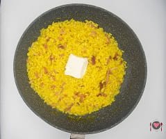 La foto raffigurante la robiolina aggiunta nel risotto zafferano e speck
