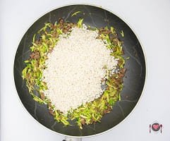 La foto raffigurante le zucchine grattugiate aggiunte alla salsiccia per la preparazione del Risotto salsiccia e zucchine