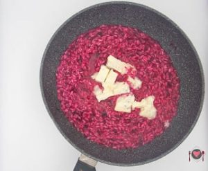 La foto raffigurante l'aggiunta di gorgonzola per la preparazione del risotto al gorgonzola