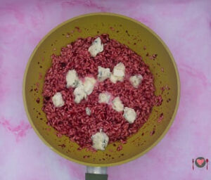 La foto raffigurante l'aggiunta del gorgonzola, per la preparazione del risotto alla barbabietola