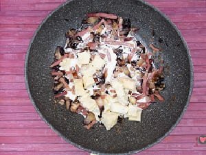 La foto raffigurante l'aggiunta di gorgonzola e panna per la preparazione degli Gnocchi gorgonzola speck e radicchio