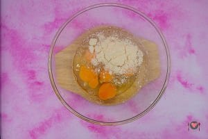 La foto raffigurante le uova con l'aggiunta di formaggio grattugiato, sale, noce moscata per la preparazione della frittata di zucchine