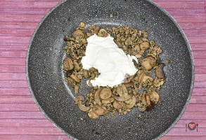 La foto raffigurante la panna e il latte aggiunti in padella per la preparazione degli gnocchi salsiccia e funghi