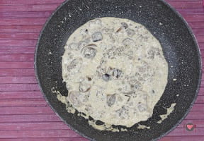 La foto raffigurante la regolazione del sugo con le spezie per la preparazione degli gnocchi salsiccia e funghi