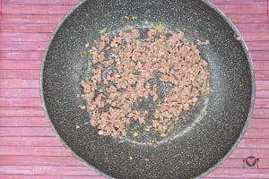 La foto raffigurante la salsiccia schiacciata a fuoco basso per la preparazione del risotto ai frutti di bosco