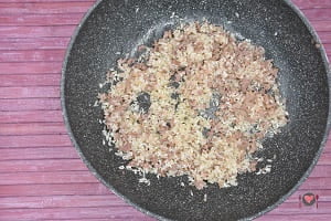 La foto raffigurante la salsiccia cotta e l'aggiunta del riso per farlo tostare