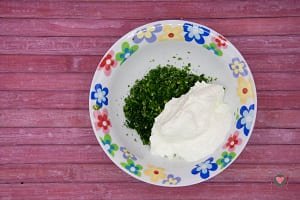La foto raffigurante l'aglio, il prezzemolo e lo yogurt per la preparazione della salsa allo yogurt