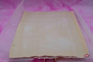 La foto raffigurante la pasta sfoglia stesa e spennellata con margarina per la preparazione dello strudel pere e cioccolato