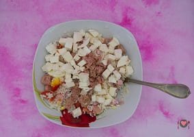 La foto raffigurante la mozzarella e il tonno aggiunti al resto degli ingredienti per la preparazione dell'insalata di riso