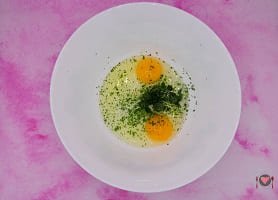 La foto raffigurante le uova sgusciate e il prezzemolo per la preparazione della cotoletta alla milanese