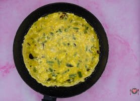 La foto raffigurante il composto a base di uova versato nella padella per la preparazione della frittata di asparagi
