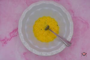 La foto raffigurante le uova sgusciate dove è stato aggiunto il formaggio grattugiato, prezzemolo, aglio, sale e pepe per la preparazione della pasta con curcuma