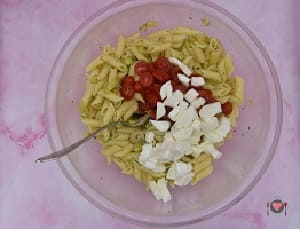 La foto raffigurante l'aggiunta dei pomodori e mozzarella per la preparazione della Pasta fredda con zucchine e gamberi