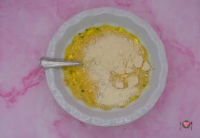 La foto raffigurante l'aggiunta del formaggio grattugiato, sale, pepe, noce moscata per la preparazione della frittata di patate