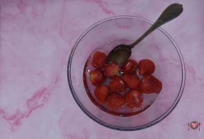 La foto raffigurante le fragole in ammollo per la preparazione della macedonia di fragole