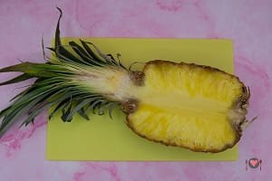 La foto raffigurante l'ananas tagliato a metà per la preparazione della macedonia di ananas
