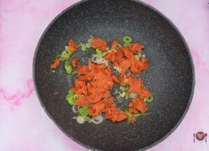 La foto raffigurante il salmone aggiunto al cipollotto per la preparazione del Risotto panna e salmone