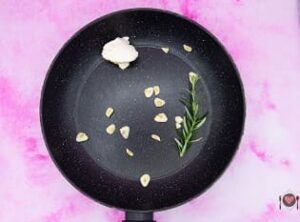 La foto raffigurante l'aglio, il burro e il rosmarino per la preparazione della torta salata zucca e salsiccia
