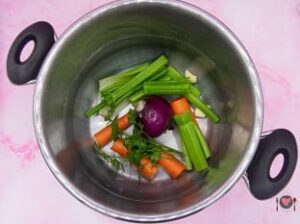 La foto raffigurante le verdure e il prezzemolo messi nella pentola per la preparazione del brodo di carne