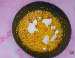 La foto raffigurante l'aggiunta della ricotta per la preparazione del risotto zucca e pancetta