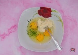 La foto raffigurante le uova, sale, pepe, prezzemolo, formaggio grattugiato, per la preparazione dell'omelette prosciutto e formaggio