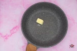 La foto raffigurante il burro gettato in padella, per la preparazione dell'omelette prosciutto e formaggio