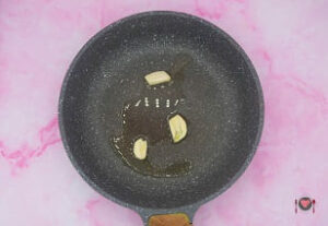 La foto raffigurante l'aglio in padella assieme all'olio, per la preparazione dei finocchi in padella