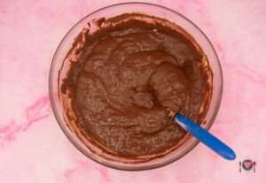 La foto raffigurante l'aggiunta di cacao, per la preparazione dei muffin cachi e ricotta