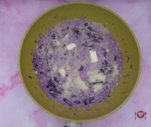 Risotto con cappuccio viola ( pronto in 30 minuti ) La foto raffigurante l'aggiunta del formaggio e burro, per la preparazione del risotto con cappuccio viola