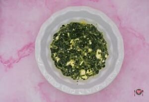 La foto raffigurante l'aggiunta degli spinaci e della feta, per la preparazione della frittata spinaci e feta