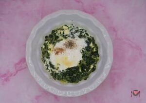 La foto raffigurante l'aggiunta di panna, sale, pepe e noce moscata, aglio in polvere, per la preparazione della frittata spinaci e feta