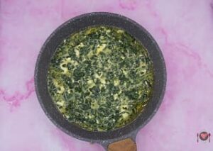 La foto raffigurante il composto di uova messo in padella, per la preparazione della frittata spinaci e feta