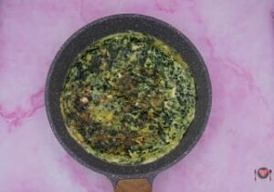 La foto raffigurante la frittata rappresa da un lato, per la preparazione della frittata spinaci e feta